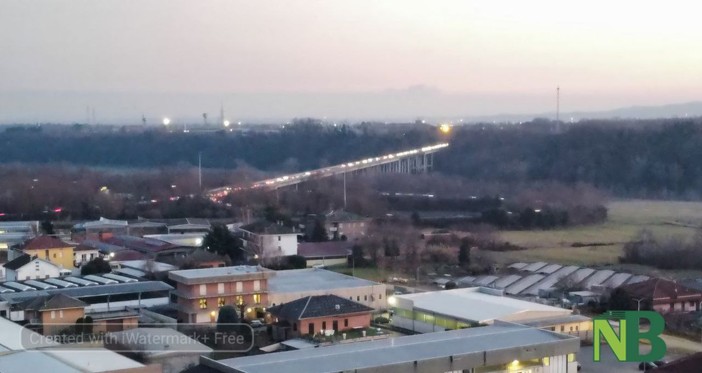 Luci sull'asfalto, il serpentone di luci sul ponte della tangenziale all'imbrunire